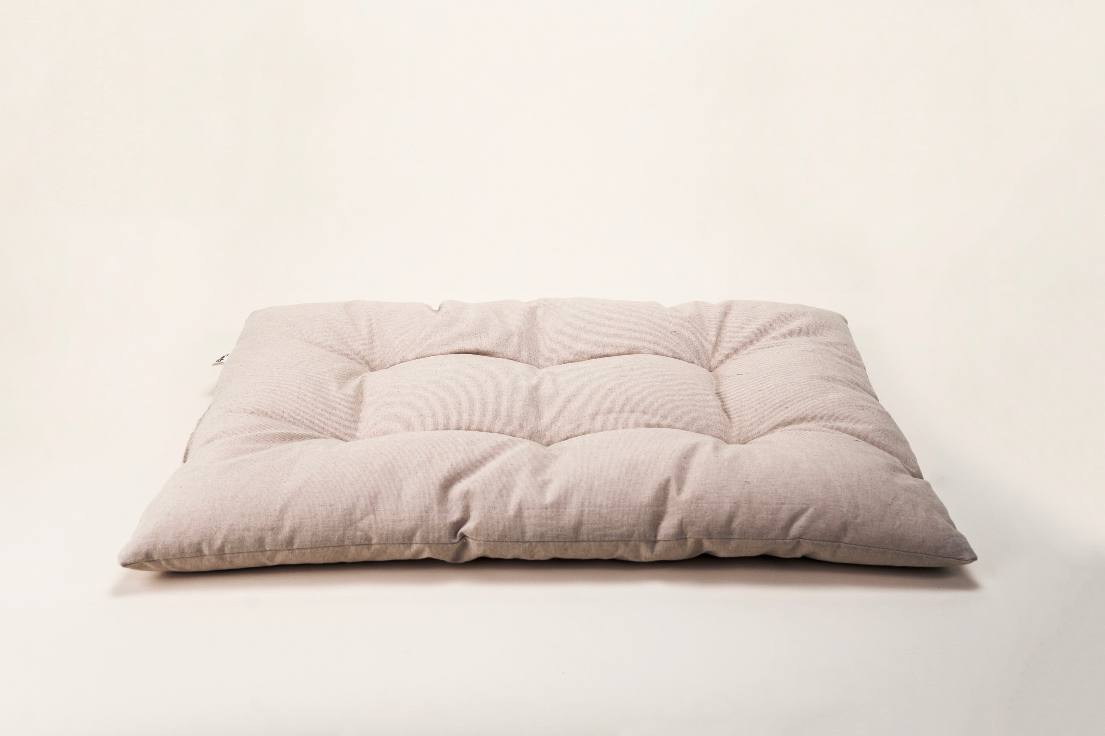 Beige cushion bed on a cream background