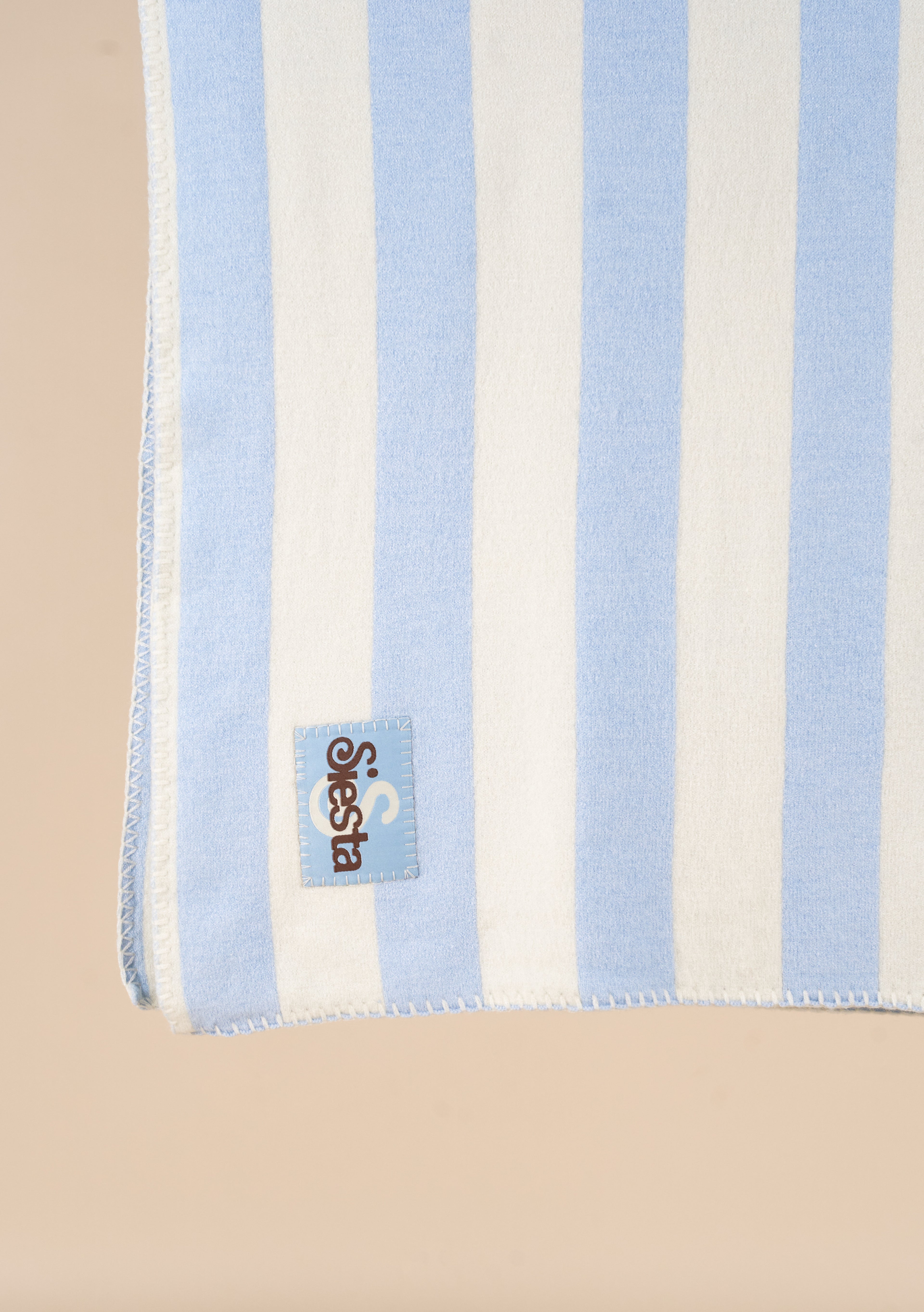 Striped towel with a logo tag on a beige background